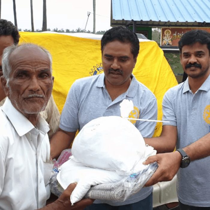 Rotarians handing food supplies to an elderly man