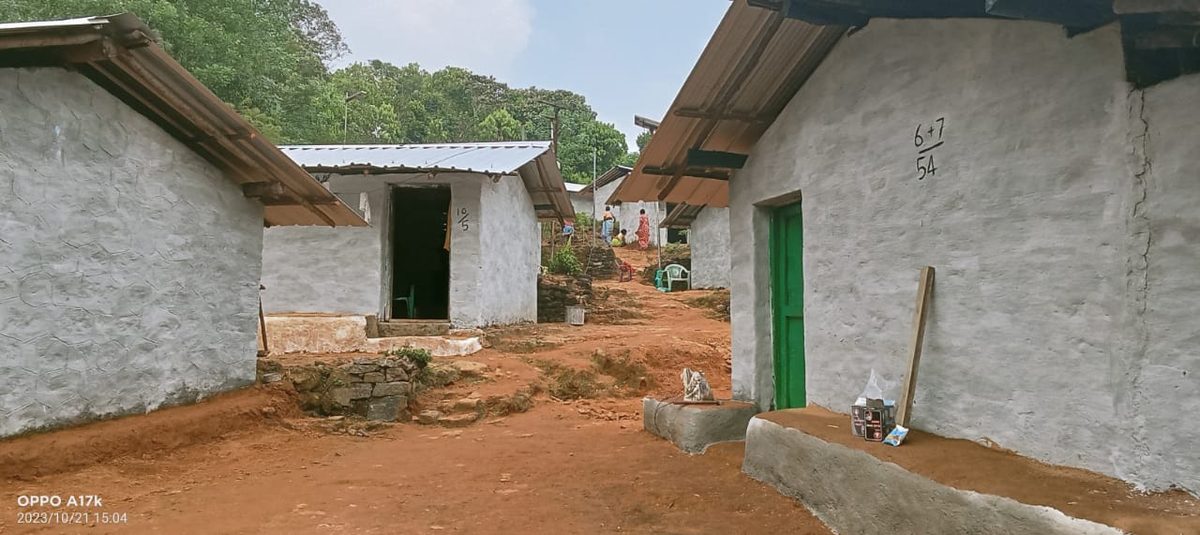 Whitewashed tribal homes with red earth paths